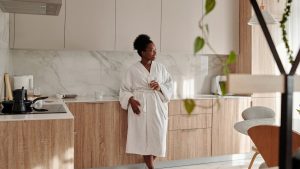 Woman drinking water in a modern kitchen in the morning — staying hydrated for fibre digestion