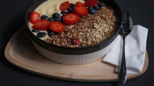 Healthy breakfast bowl with granola, strawberries, blueberries and yogurt for gut health