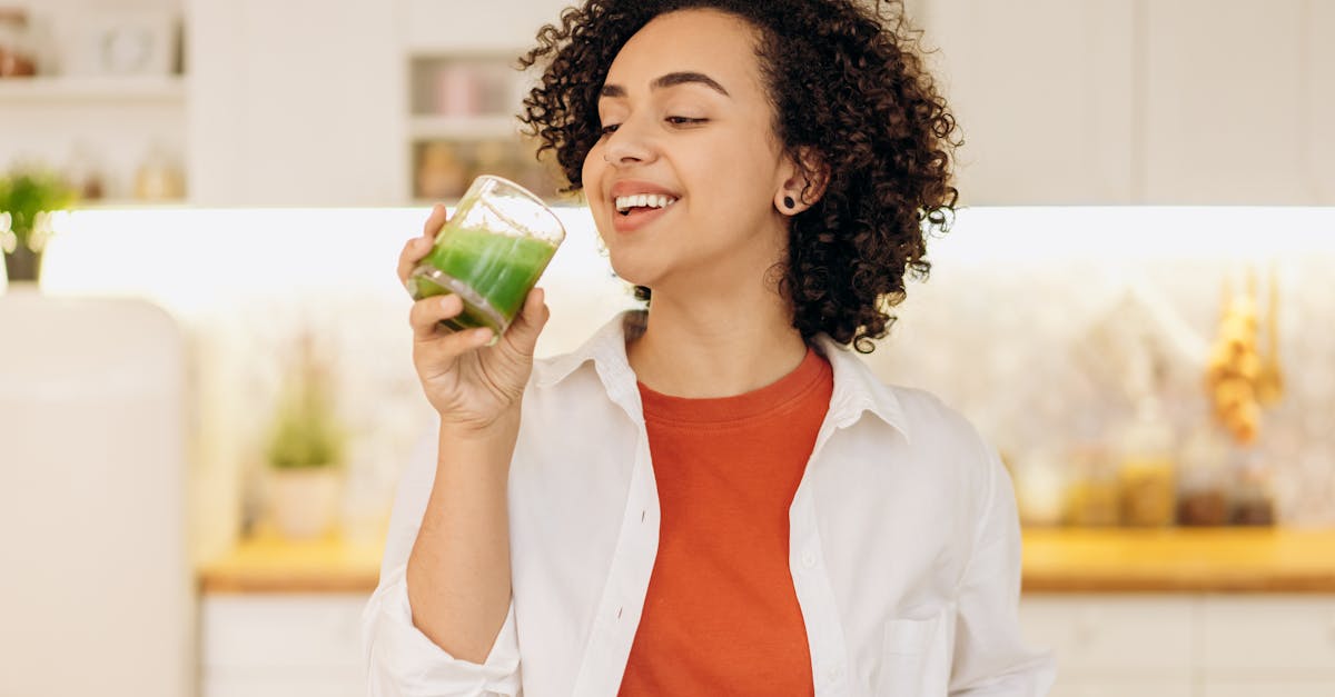 Woman drinking a fresh green smoothie in a bright kitchen — morning gut health routine