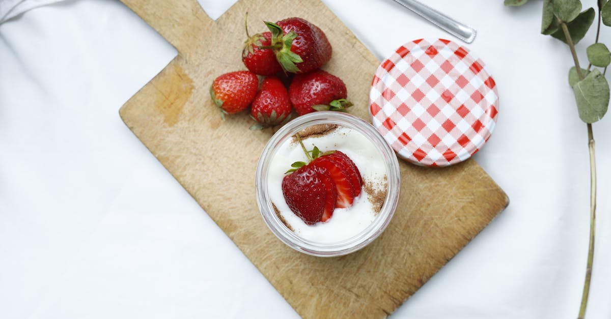 Jar of strawberry yogurt — live cultures from fermented food alongside a synbiotic supplement