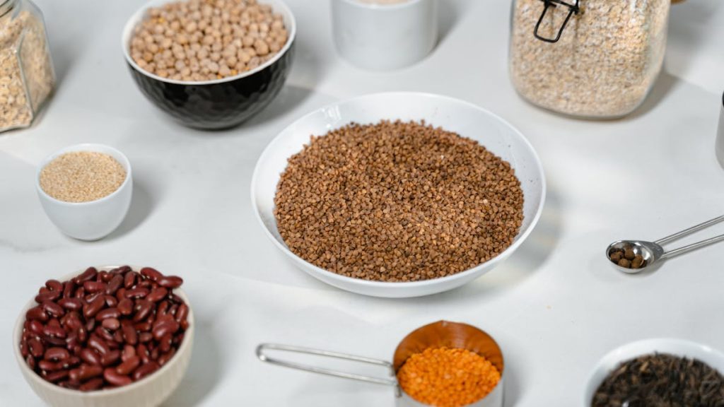 Bowls of oats, beans, lentils and other soluble fibre foods on a white surface