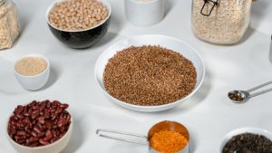 Bowls of oats, beans, lentils and other soluble fibre foods on a white surface